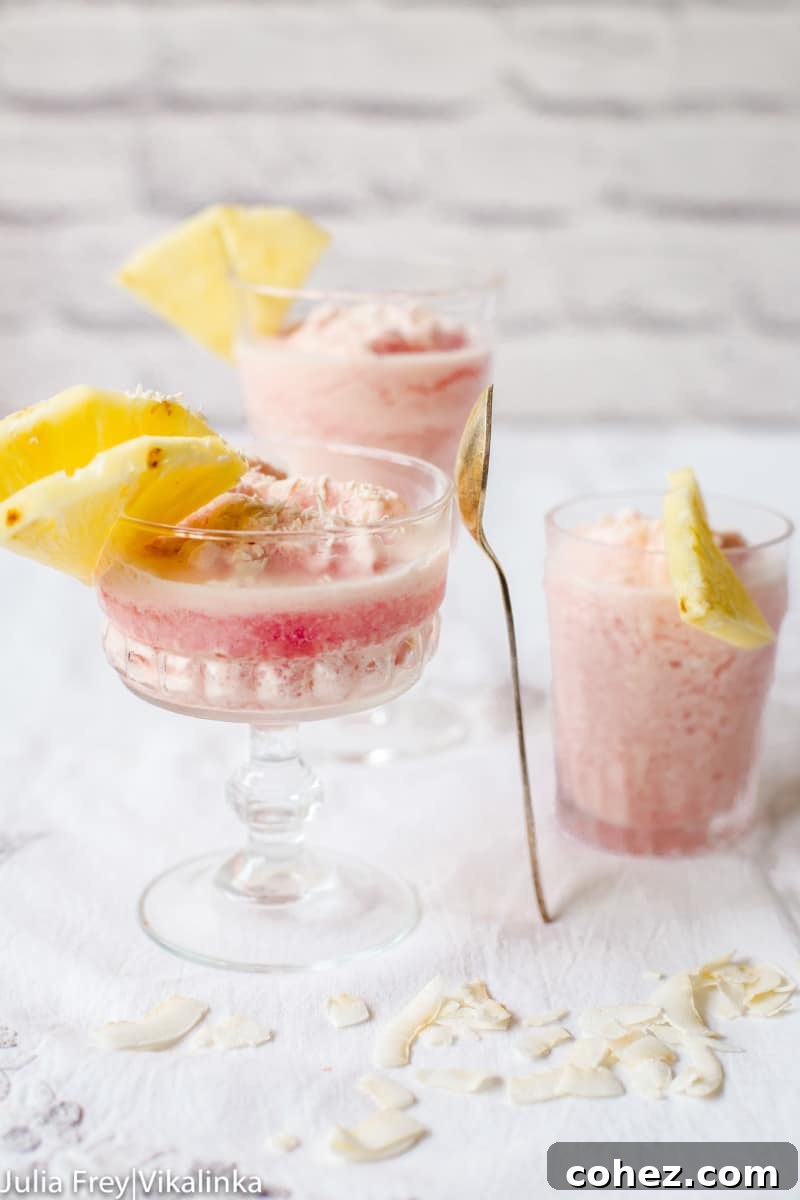 Frozen Blood Orange Pina Colada topped with pineapple slices and a blood orange wedge