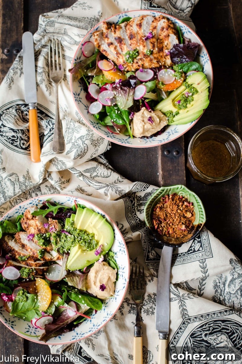 Top down view of multiple salad bowls with zhoug and pomegranate vinaigrette