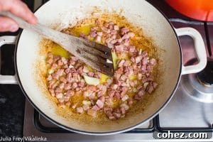 Effortless Cream-Free Carbonara Sauce 9 Wooden spatula mixing bacon in pan