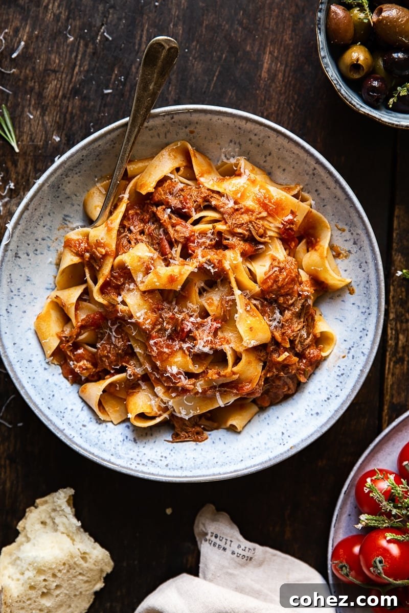 Close-up shot of pappardelle pasta generously coated in rich Italian beef ragu, ready to be enjoyed.