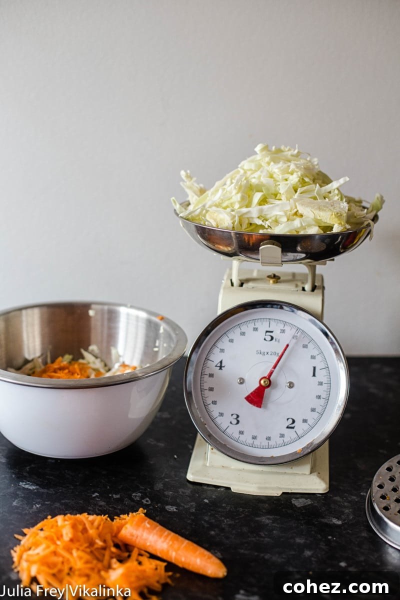 Process shot showing sliced cabbage and grated carrots, the primary ingredients for sauerkraut, ready for mixing.