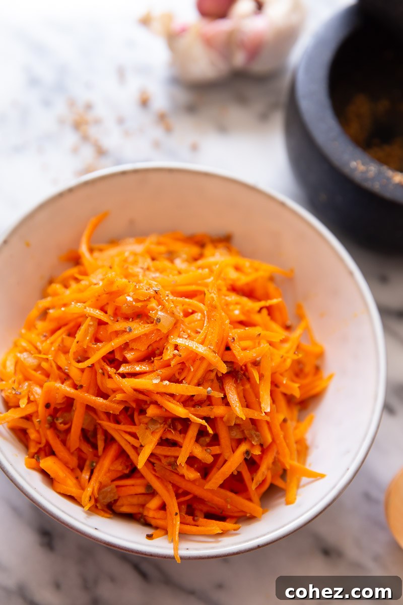A beautifully presented bowl of Korean Carrot Salad, highlighting its vibrant orange color and fresh appearance.