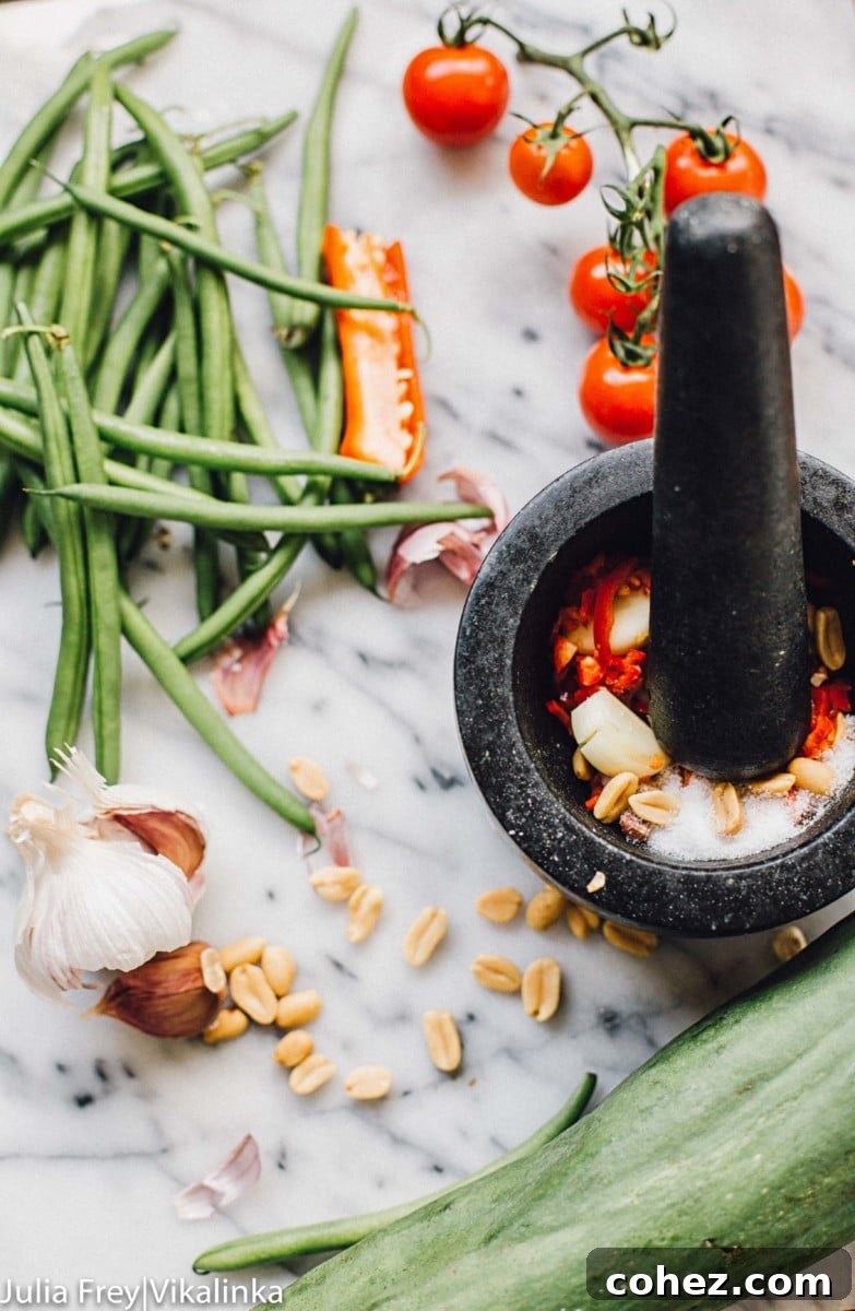 Fiery Som Tam Papaya Salad 3 Traditional Thai pestle and mortar used for grinding ingredients for Som Tum dressing, with fresh chilies and garlic visible.