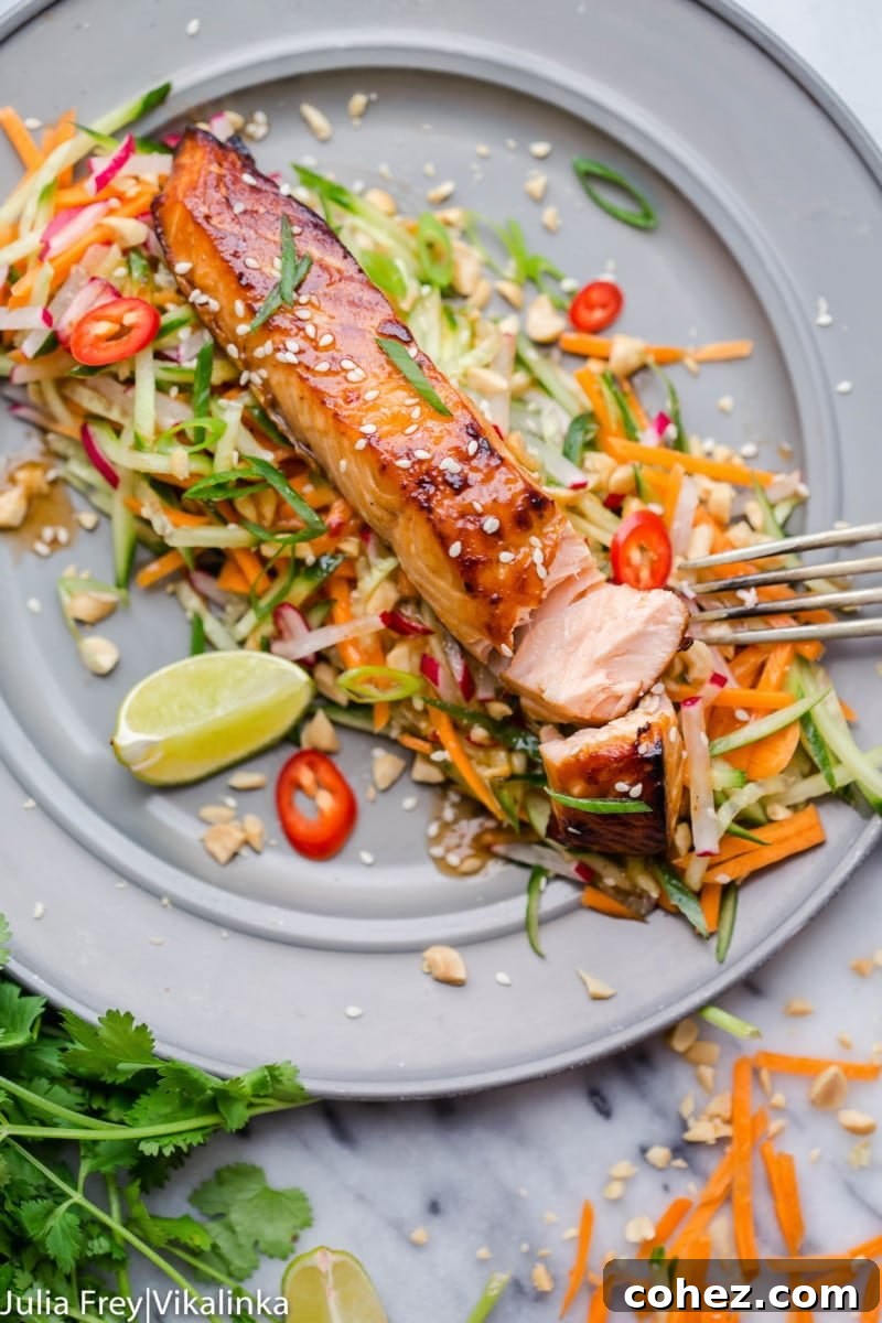 Beautifully glazed Asian salmon fillets resting on a bed of vibrant carrot and cucumber slaw, ready to be served.