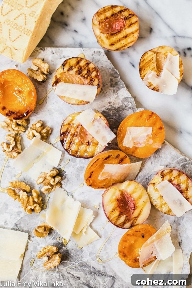 Stone fruit on a marble slab with walnuts and cheese shavings