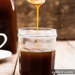 Spoon pouring pumpkin spice syrup into a jar
