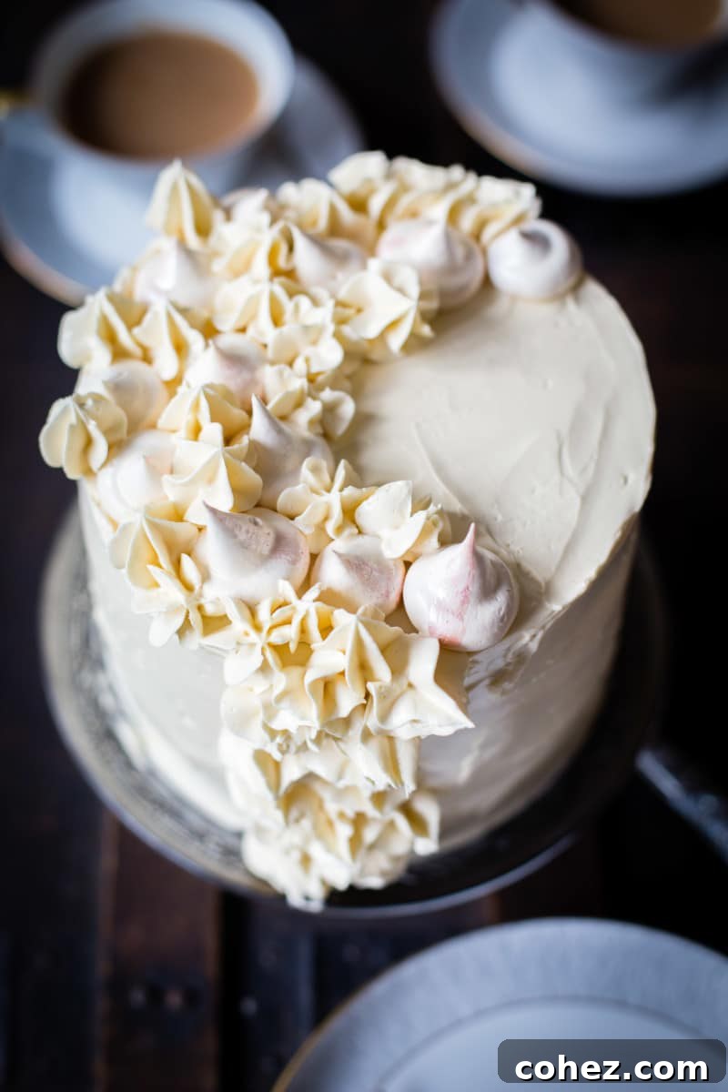 Close-up view of the top of the Earl Grey meringue cake, showcasing delicate meringue pieces and a dusting of tea leaves.