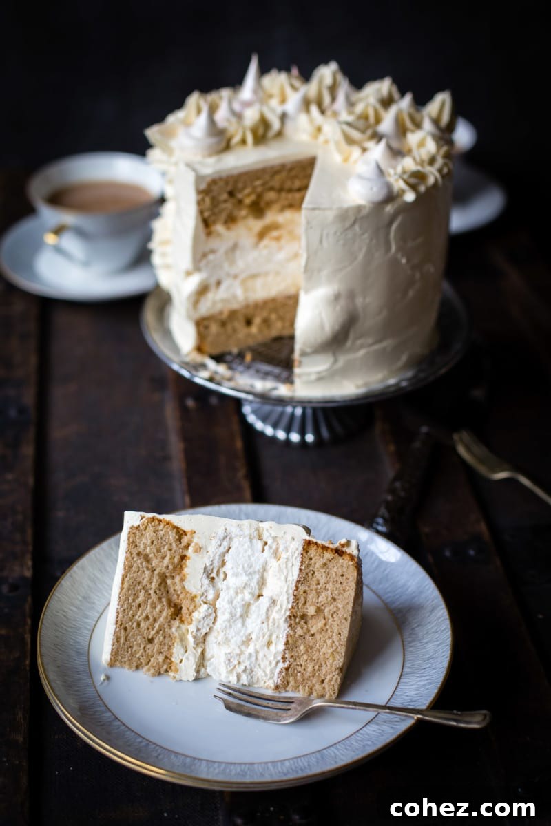 A delicious piece of Earl Grey meringue cake resting on a plate, with the rest of the cake gracefully blurred in the background.