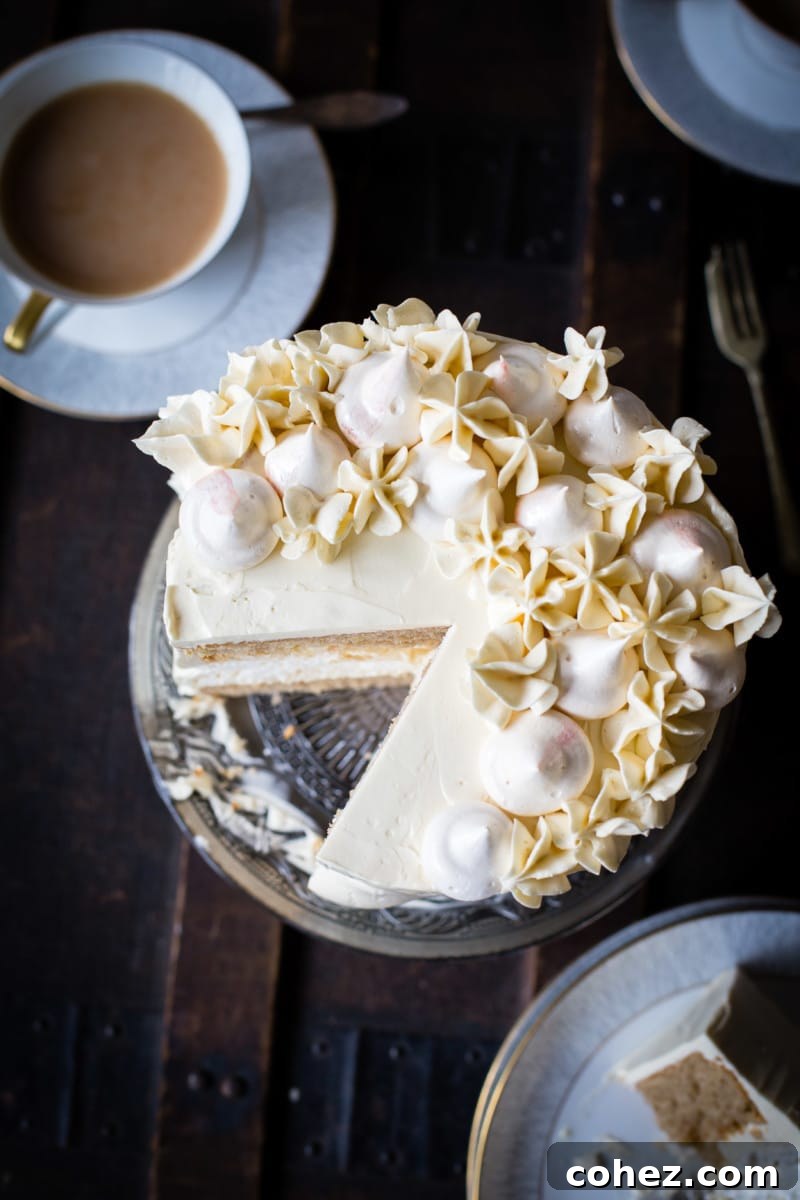 A top-down view of the beautifully decorated Earl Grey meringue cake with a single piece gracefully removed, inviting a taste.