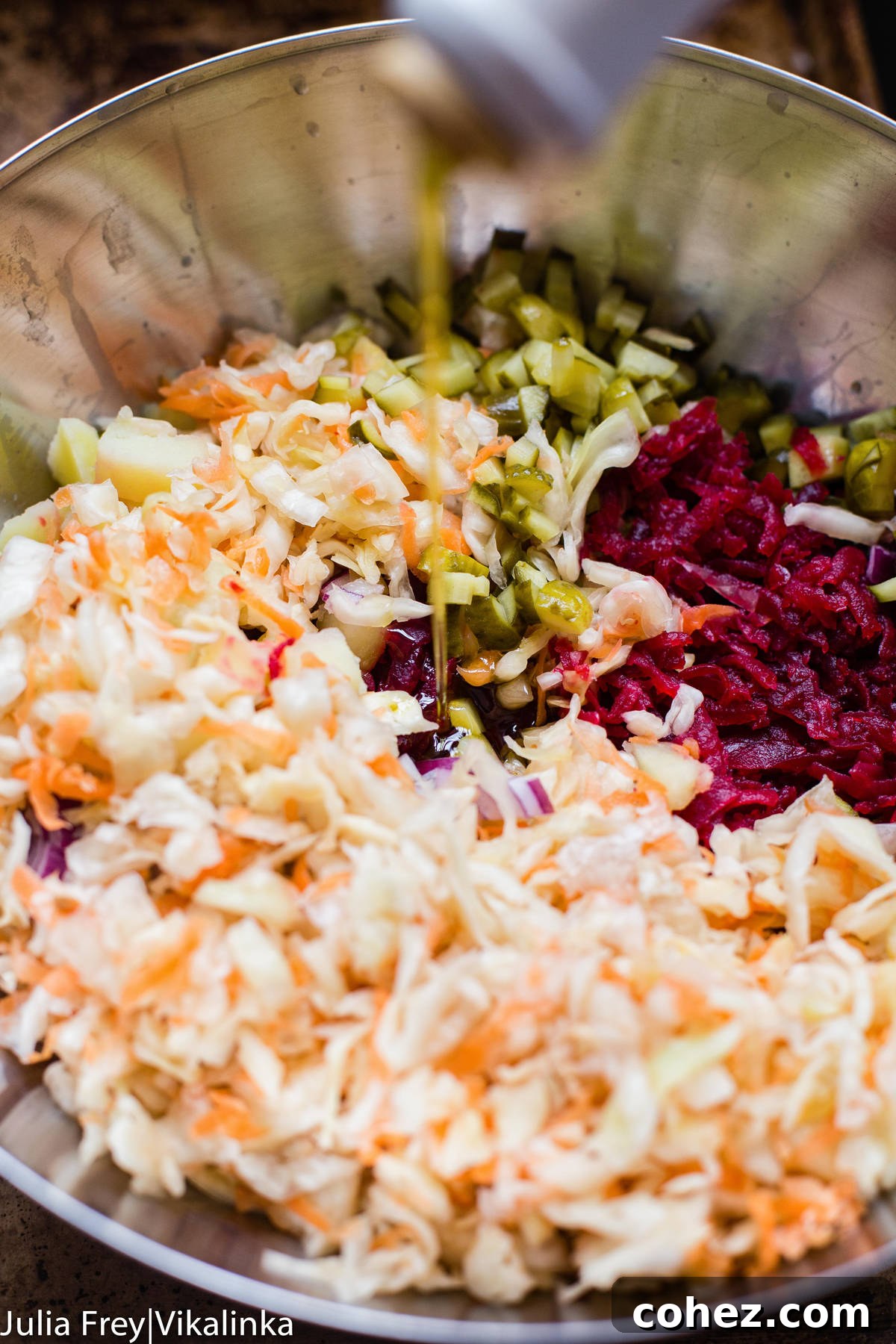 Preparing Vinegret: sauerkraut, grated beets, and diced pickles in a stainless steel mixing bowl before combining.