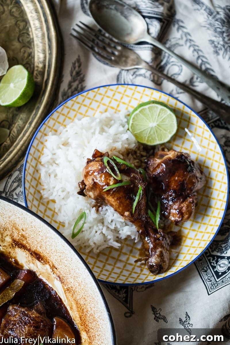 Plate of rice with chicken on top alongside lime slice