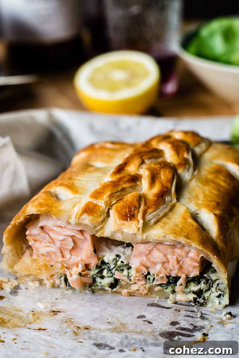 Regal Salmon in Golden Crust 2 Exquisitely baked Salmon en Croute, revealing the succulent salmon and creamy filling peeking through the golden puff pastry.