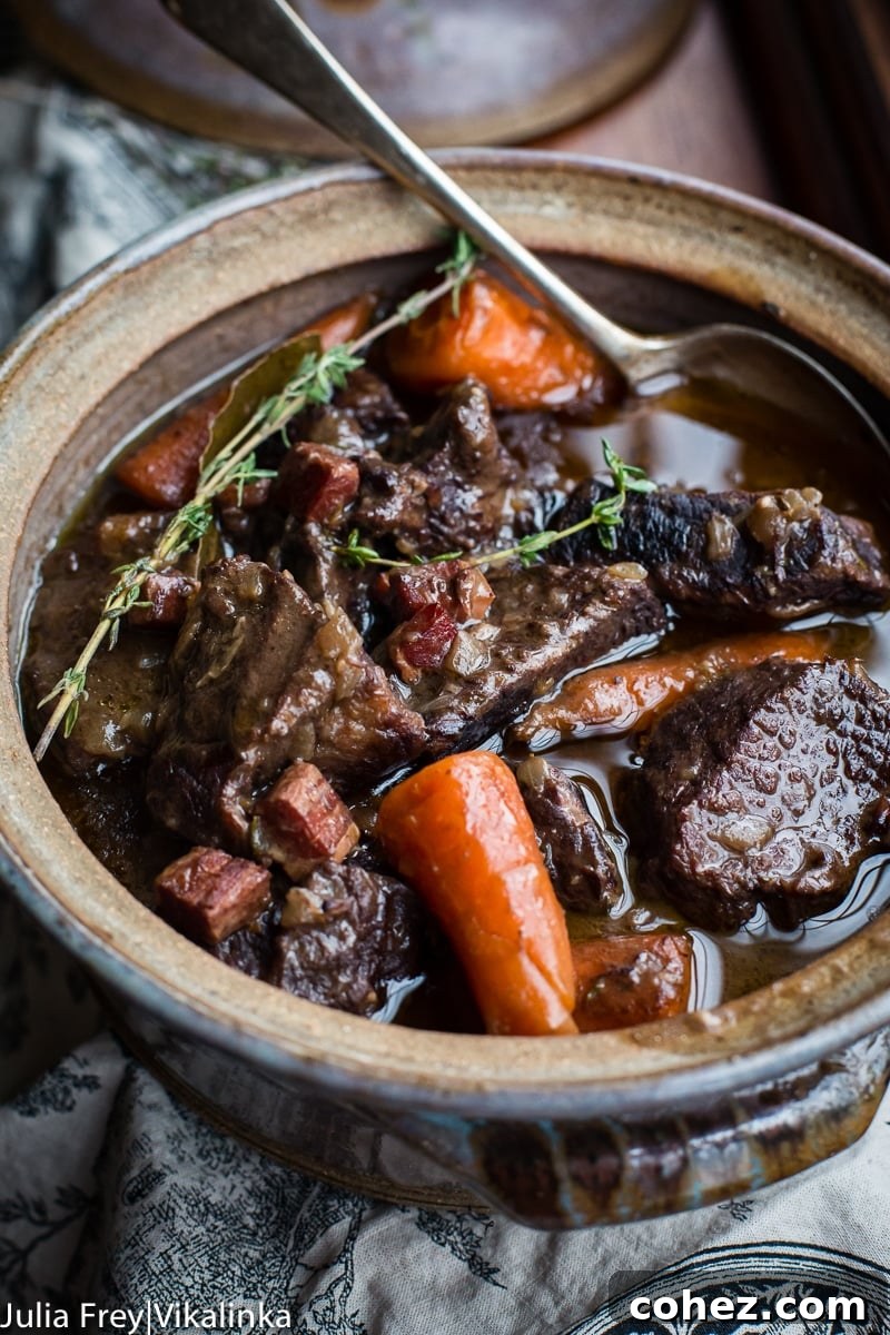 A generous serving of Beef Bourguignon presented in a beautiful ceramic serving dish