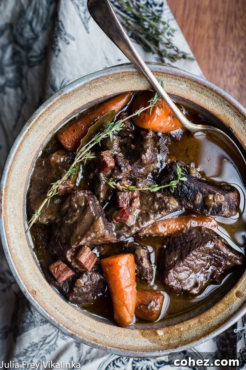 A top-down view of Beef Bourguignon artfully arranged in a serving dish, showcasing its rich texture and color