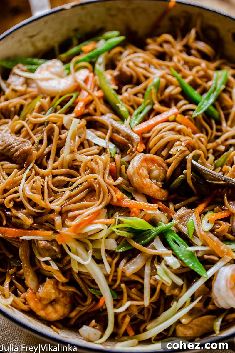Flavorful Filipino Pancit Canton noodles with green beans, carrots, pork and shrimp, served fresh from the pan.