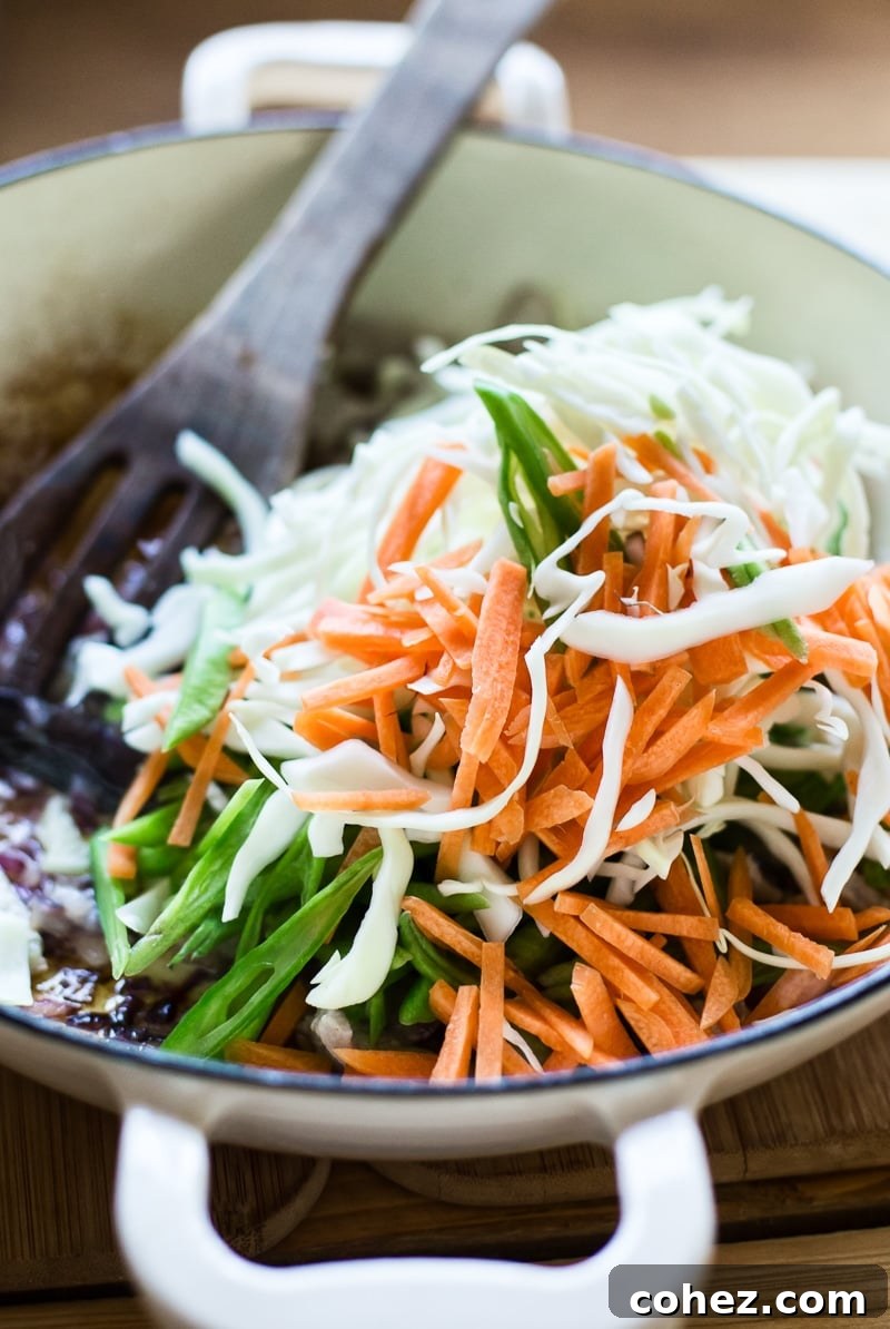 Finely sliced cabbage, carrots, and green beans prepared in a pan, ready for stir-frying in Pancit Canton.