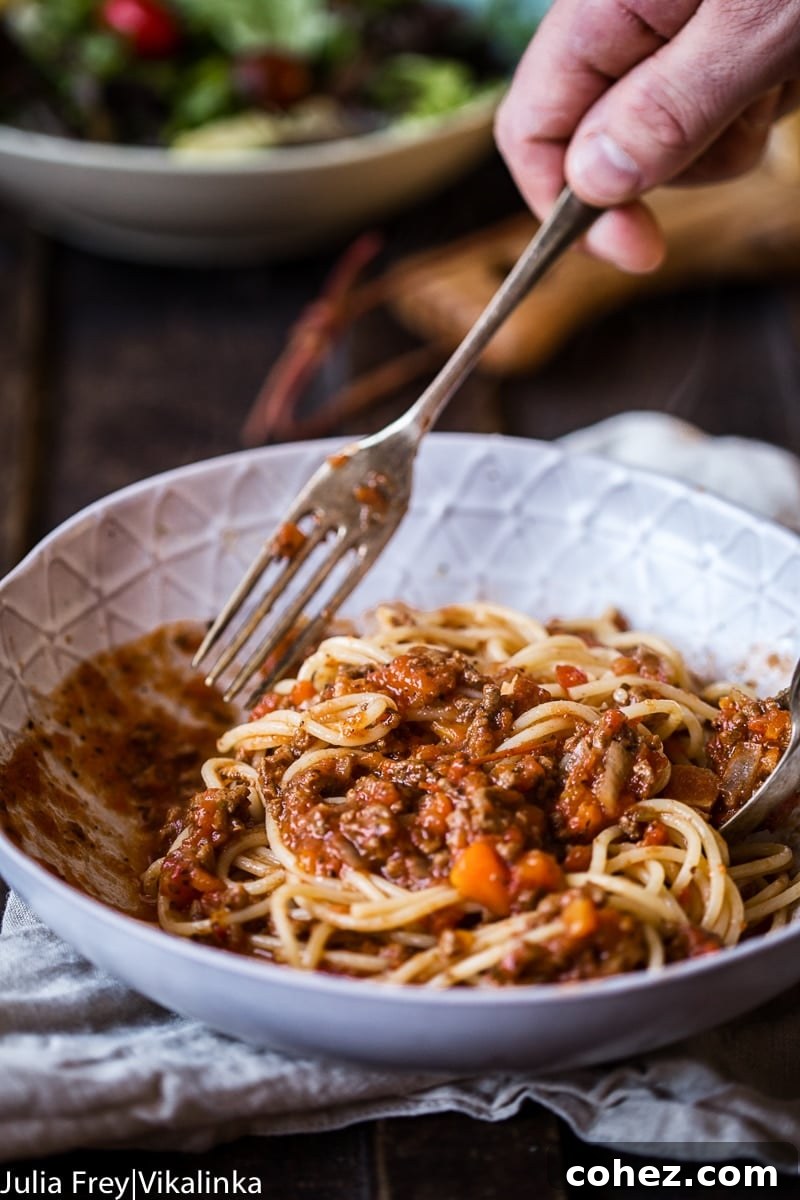 Savory Slow Cooked Bolognese Ragu 3 Close-up shot of slow cooker beef bolognese sauce simmering gently, showcasing its rich texture and deep color, promising incredible flavor.