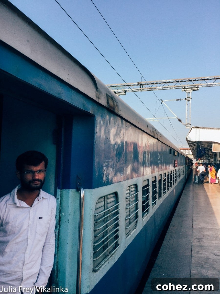 Indian train station platform, with people waiting and trains