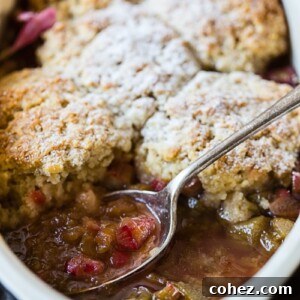 Rhubarb cobbler in a pan, showcasing its golden topping and vibrant filling.