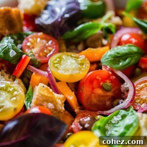 A close-up of vibrant tomato and basil salad, featuring a mix of red and yellow cherry tomatoes and fresh green basil leaves.