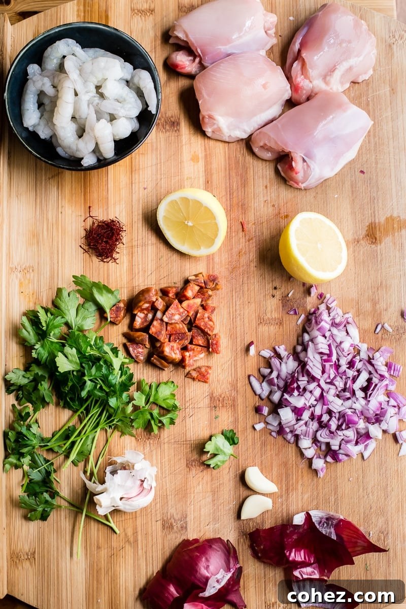 A selection of fresh Spanish rice ingredients, including rice, chicken, shrimp, chorizo, lemon, and herbs, arranged neatly on a wooden cutting board.
