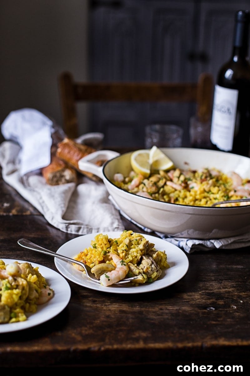A cozy dinner table setting, featuring a pan of Spanish rice with chicken and shrimp, plates, and glasses, creating a warm and inviting atmosphere.