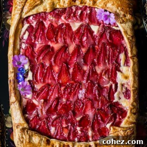 View of strawberry galette with pink flowers as decoration