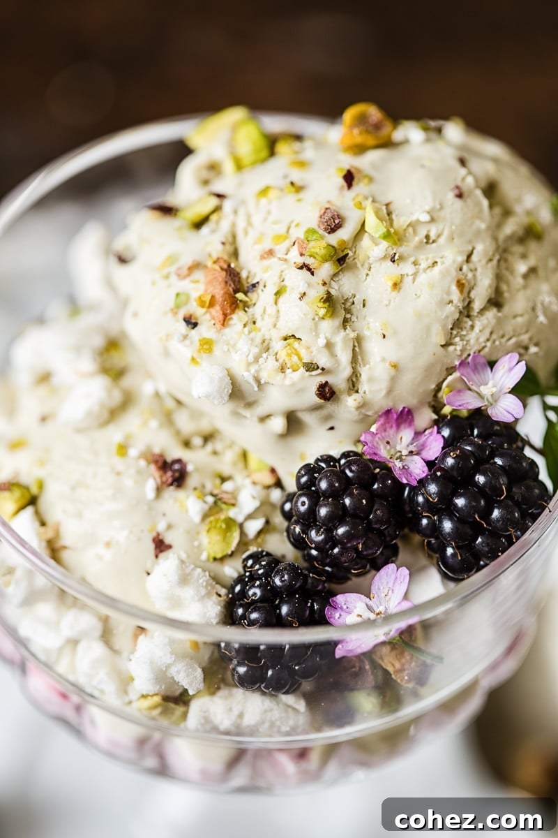 Glass dish with the pistachio ice cream Eton mess and three blackberries