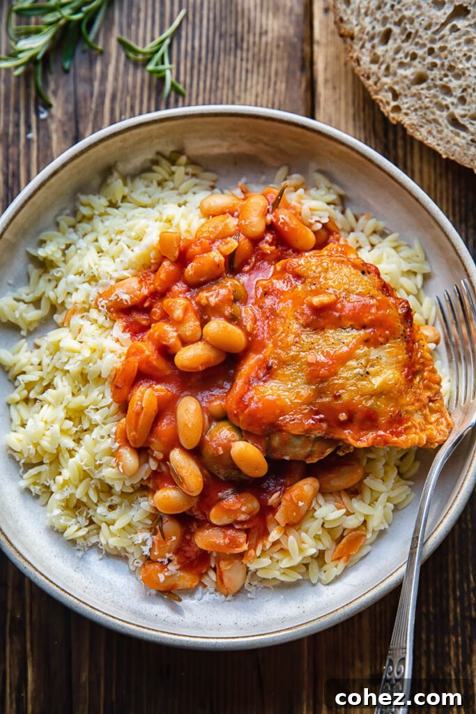 plate with rosemary chicken stew overtop rice with a fork