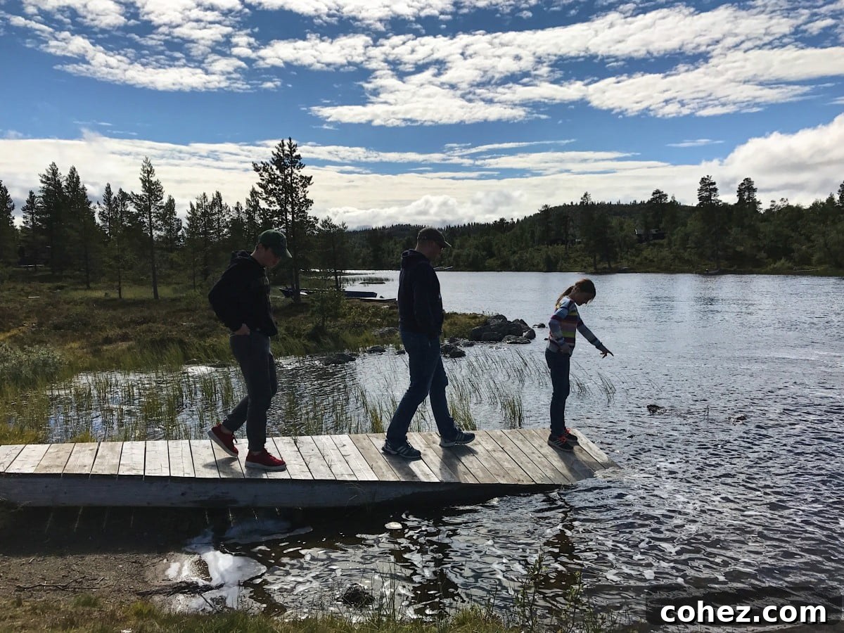 Child playing by a campfire on a lake beach in Sweden