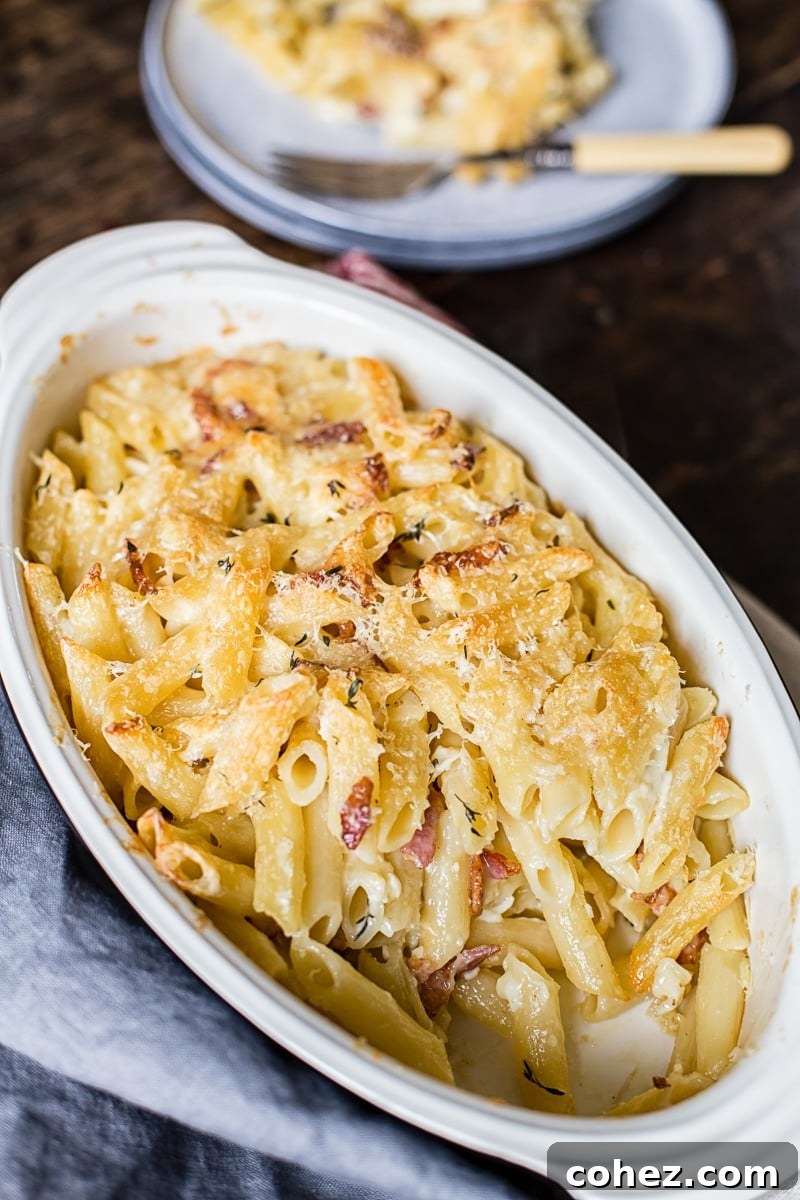 Large baking dish filled with golden-brown Brie and Bacon Macaroni and Cheese, fresh from the oven, showing a bubbling, cheesy crust.