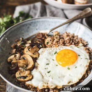 Buckwheat with mushrooms and fried egg in a bowl with a fork