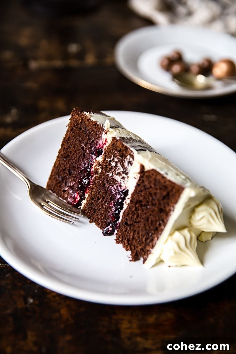 Piece of the black and white cake on a plate with fork