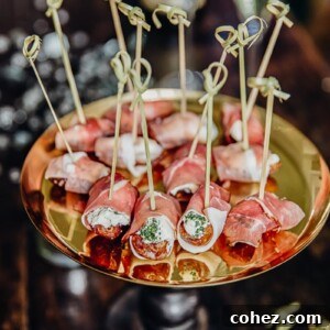 Herby Cheese Stuffed Dates Wrapped in Prosciutto on a cake stand