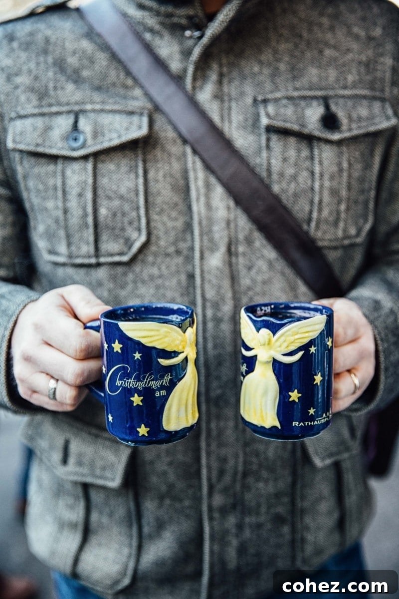 Two mugs of steaming glühwein, garnished with cinnamon, from a Vienna Christmas Market