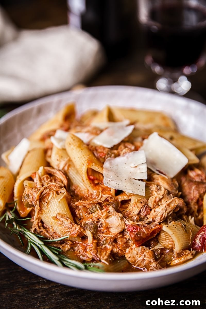 Bowl of chicken ragu pasta with large cheese shavings