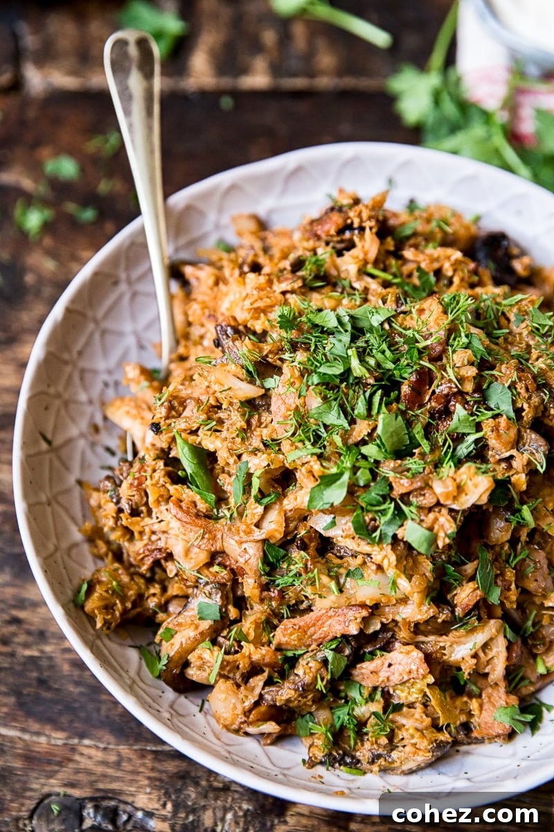 A serving of braised savoy cabbage in a bowl, with a spoon resting invitingly inside, highlighting its rich texture and appetizing appeal.