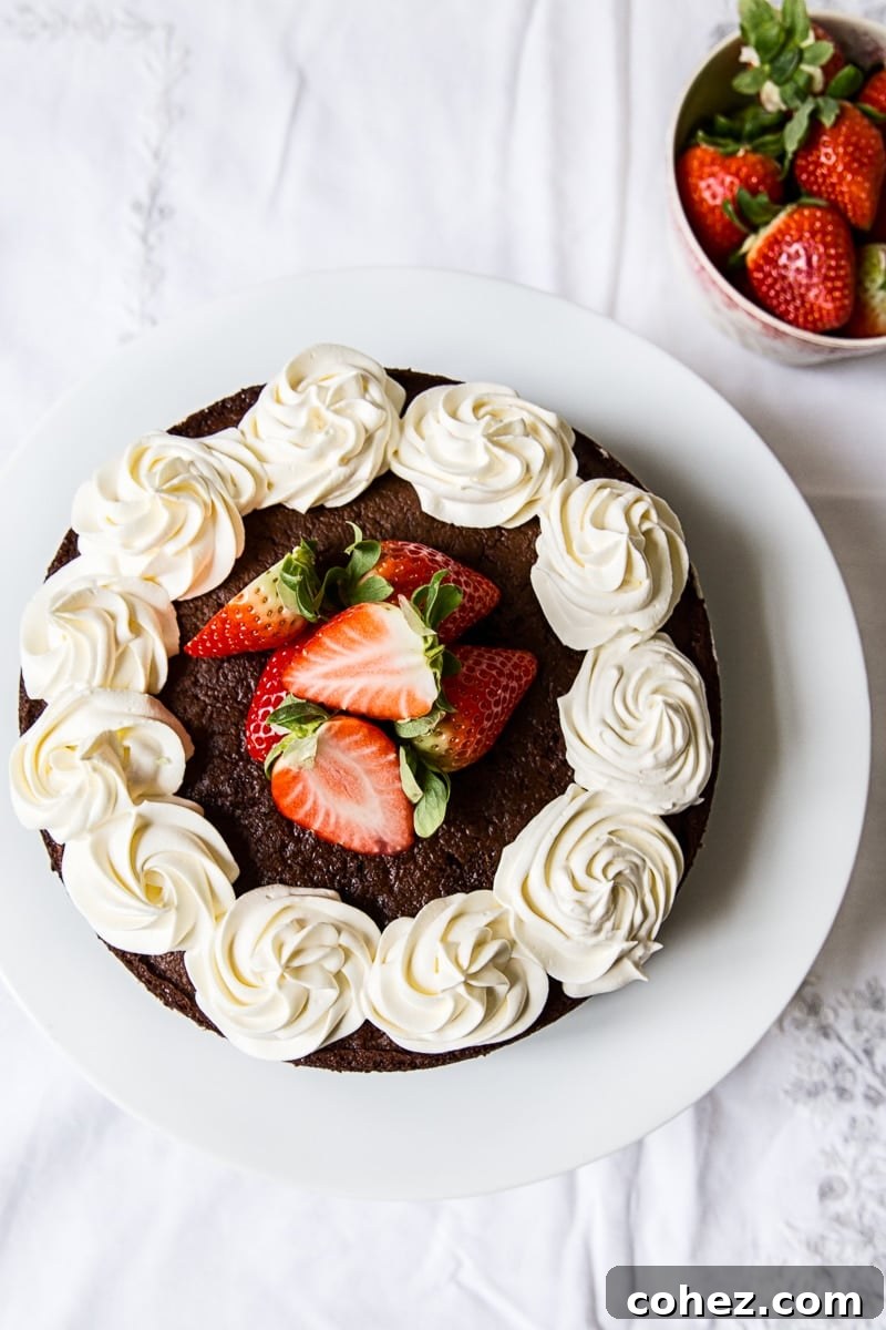 Top-down view of a beautifully decorated Chocolate Strawberry Mousse Cake with fresh strawberries.