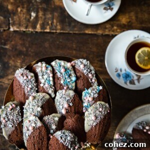 Top down of a plate of Chocolate Madeleines with cups of tea