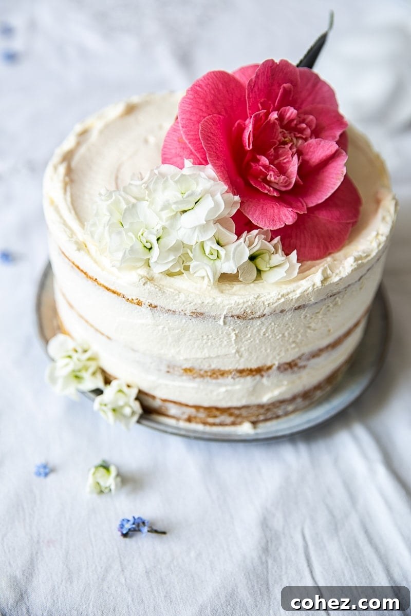 Beautifully decorated Elderflower, Lemon and Summer Berry Cake on a rustic wooden table