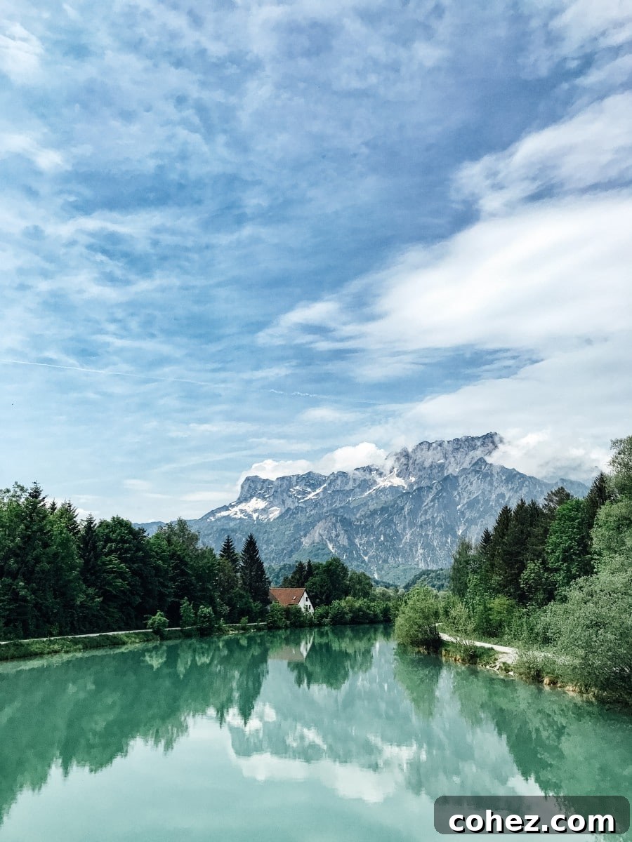 Salzburg's Brews and Baroque Wonders 2 Lush mountain landscape with a verdant valley and a clear river flowing through it, characteristic of the scenery outside Salzburg, Austria.