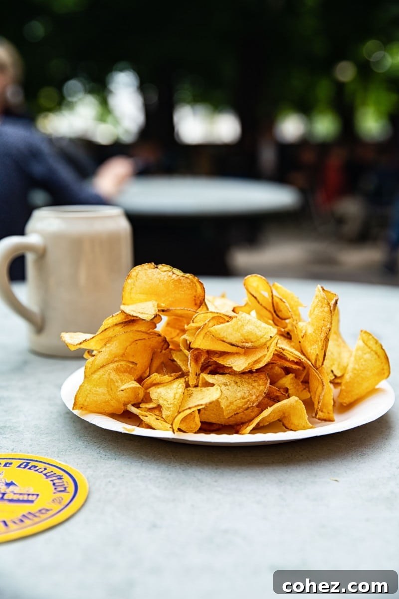 Salzburg's Brews and Baroque Wonders 8 A classic pairing of golden, crispy potato chips and a traditional mug of beer from Augustiner Bräu, set in a relaxed pub atmosphere.