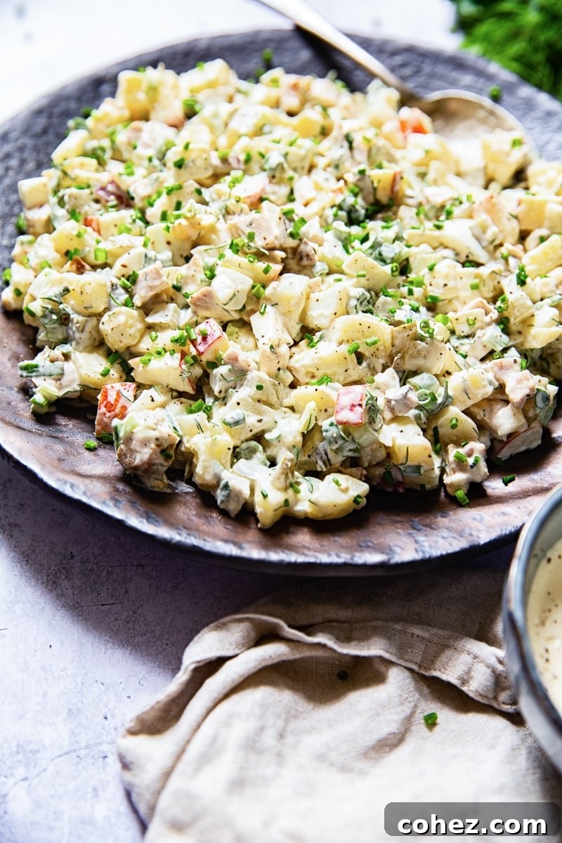 Side view of a creamy, inviting potato salad served on a rustic brown platter.
