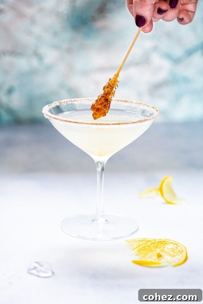 Side shot of sugar coated stir stick dipping into Lemon Drop Martini