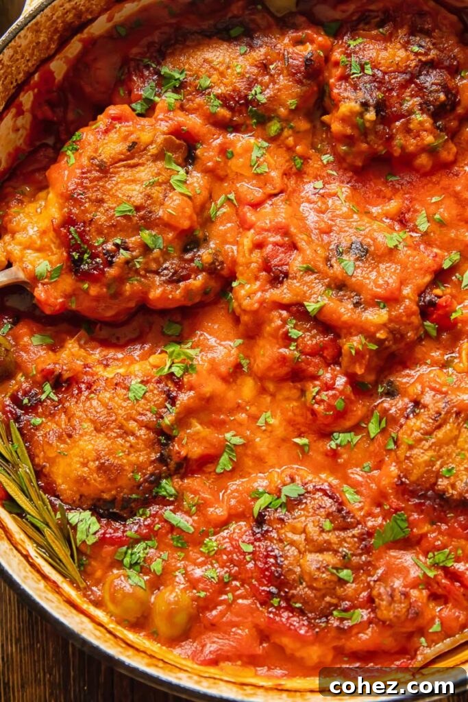 Weeknight Chicken Cacciatore 3 Close-up photograph of the rich, savory Cacciatore tomato sauce bubbling gently in a pan, infused with herbs and garlic, with chopped fresh parsley sprinkled over for garnish.