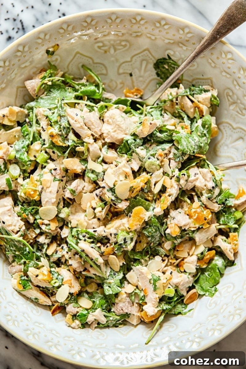 Perfect Coronation Chicken 4 A close-up of a large bowl of Coronation Chicken Salad with a serving spoon, ready to be enjoyed