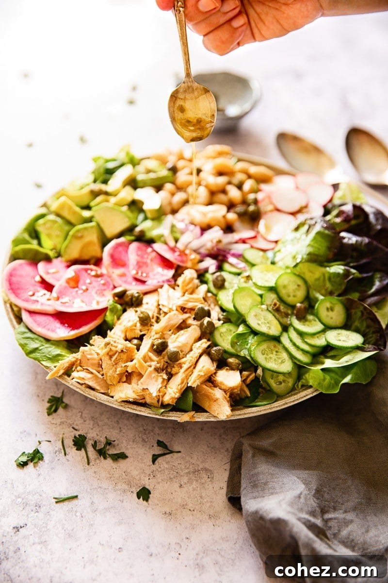 Healthy tuna salad with a spoon drizzling dressing