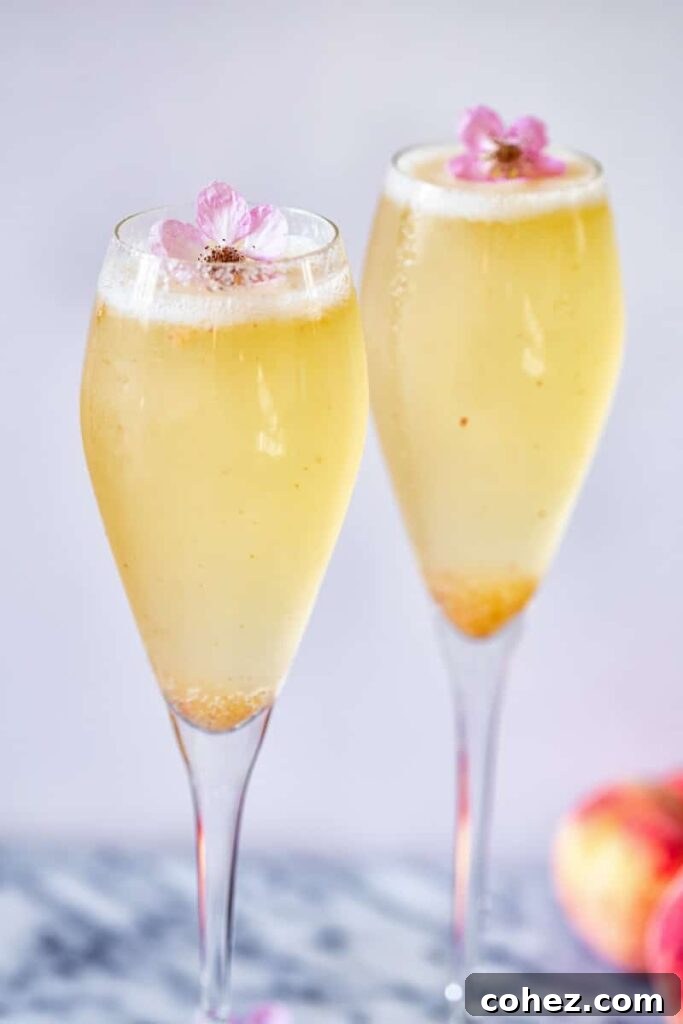 Two glasses with Elderflower Peach Bellini and flower garnish
