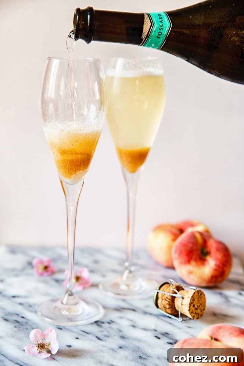 Two champagne glasses being filled with prosecco alongside peach