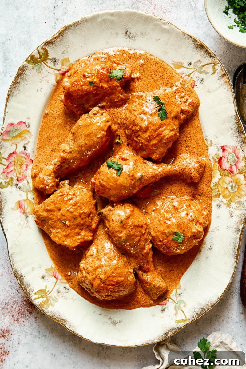 Velvety Hungarian Paprika Chicken 2 A stunning plate of Hungarian Chicken Paprikash, featuring tender chicken pieces bathed in a creamy, red paprika sauce, garnished with fresh parsley.